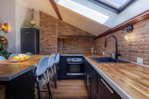 une cuisine avec un comptoir en bois et un mur en briques dans l'établissement Appart près de Disneyland «les yeux vers le ciel », à Meaux