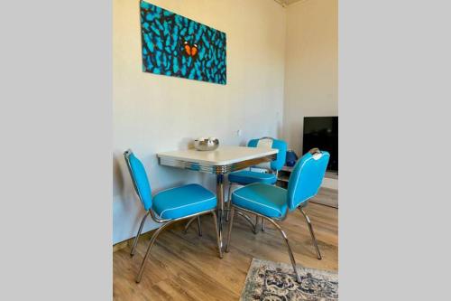 a dining room with blue chairs and a table at Roggendorf in Mechernich