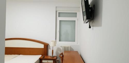 een slaapkamer met een bed, een bureau en een raam bij Aloja Madrid in Madrid