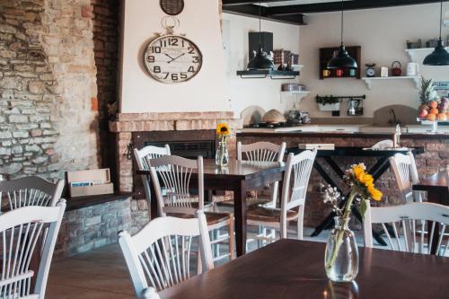 a dining room with a table and chairs and a clock at La Rola in Albaretto Della Torre 