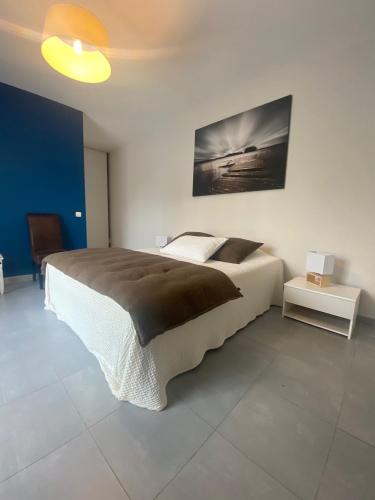 une chambre avec un grand lit et un tableau au mur dans l'établissement Les Centaurines, à Saint-Siffret