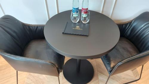 a table with two chairs and a table with drinks on it at Relais Villa Margherita in Longiano