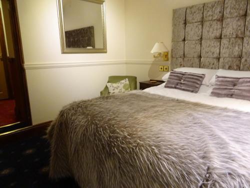 a bedroom with a large bed and a mirror at The Grange at Mortimers Cross 