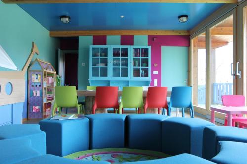 a room with a blue couch and colorful chairs at Giardino Ascona in Ascona