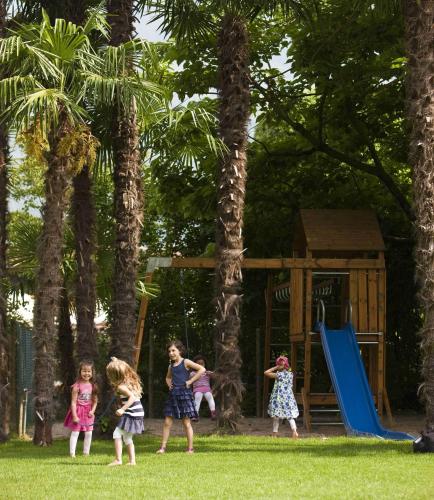 a group of children playing in a park with a playground at Giardino Ascona in Ascona