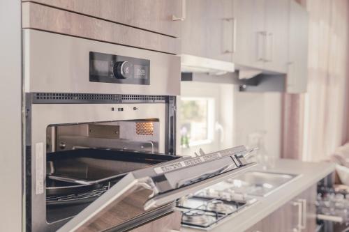 a kitchen with an open oven in a kitchen at Cosy Cabin - 4 pers in Zuna