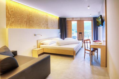 sypialnia z łóżkiem i biurkiem z krzesłem w obiekcie Kleinkunsthotel w mieście Naturns