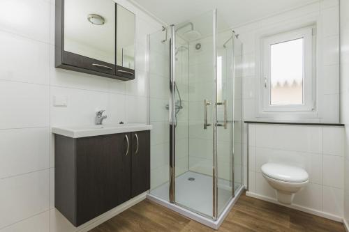 uma casa de banho com uma cabina de duche em vidro e um WC. em Cosy Cabin - 6 pers em Zuna