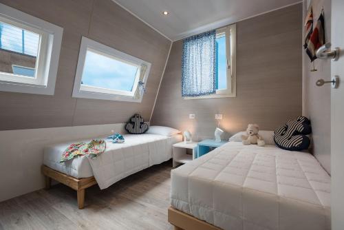 een slaapkamer met 2 bedden en een teddybeer bij Marina houseboat 2 pax in Lignano Sabbiadoro