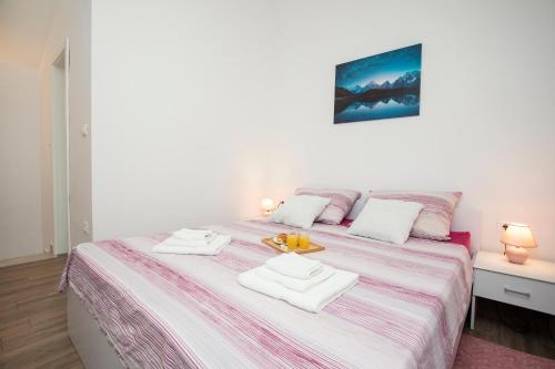 sypialnia z dużym łóżkiem i 2 białymi ręcznikami w obiekcie Studio apartman Amalie w mieście Pazin