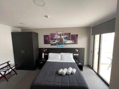 um quarto com uma cama preta e 2 almofadas brancas em 6 Bis HOTEL em Castelldefels