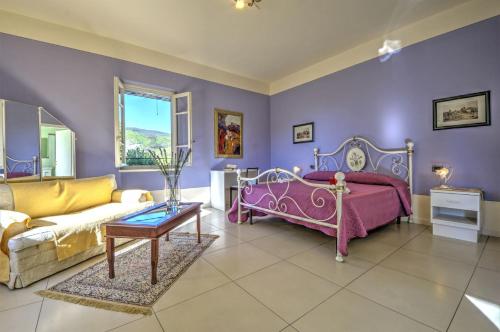 a purple bedroom with a bed and a couch at Lucca Cycling Holidays Il Tiglio Rooms in Lucca