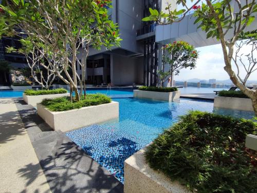 a pool in a building with trees and blue water at Melaka Town - Imperio Residence Studio With Bathtub in Melaka