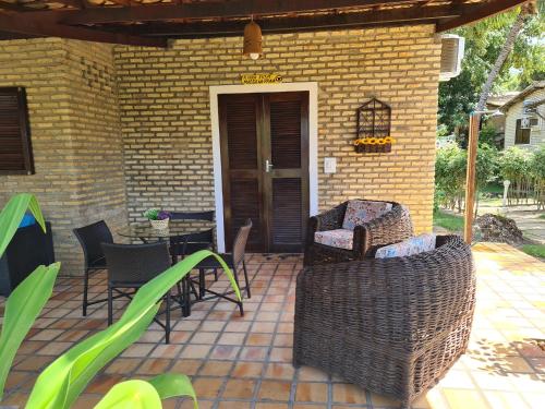 a patio with chairs and a table in front of a house at Chalé 17 - Porto do Sol - Pipa in Pipa