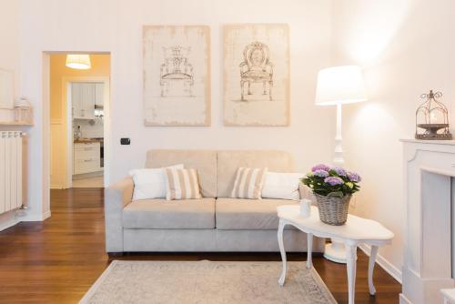 La Mansarda Segreta Mood Apartment في فيرونا: غرفة معيشة مع أريكة وطاولة