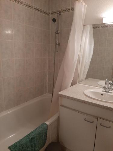 une salle de bain avec une baignoire, un lavabo et une douche dans l'établissement Joli T2 - Emeraude 28, à Canet