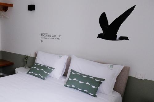 a bedroom with a bed and a bird flying above it at Boa Nova Hostel in Santa Cruz da Graciosa