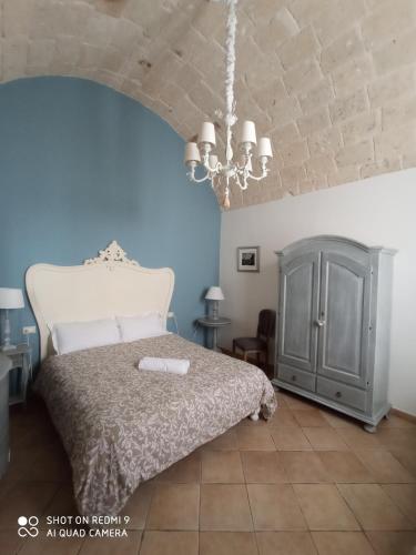 a bedroom with a bed and a chandelier at B&B La Porta Vecchia in Monopoli