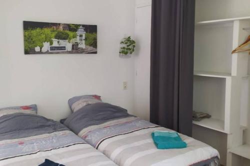 - un lit dans une chambre avec une photo sur le mur dans l'établissement 12 RDC Appartement 2 chambres jardin terrasse, à Plonéour-Lanvern