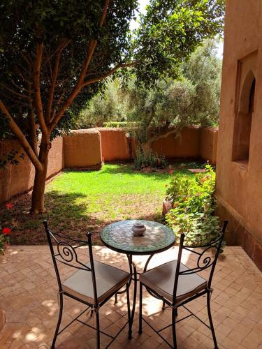 a patio with a table and two chairs on a patio at La Maison Des Oliviers in Marrakesh