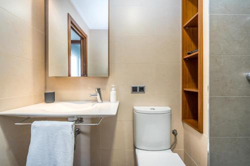 a bathroom with a toilet and a sink and a mirror at Mar Apartment in Altea