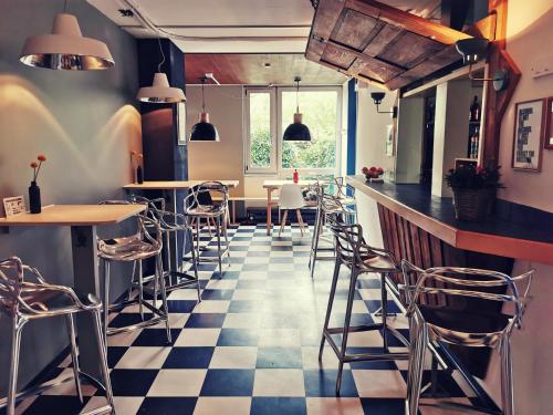 um restaurante com piso em xadrez e bancos de bar em Backpackers Luzern em Lucerna
