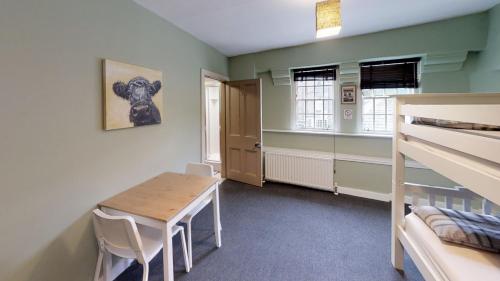 a room with a table and a bunk bed at Dundee Backpackers Hostel in Dundee