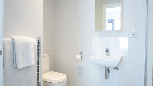 a white bathroom with a toilet and a sink at Modern Apartment with FREE Parking, WIFI and Netflix in Stratford-upon-Avon