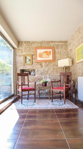 a living room with two chairs and a table at Eira House - Quinta de Fundevila in Vieira do Minho