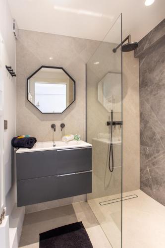 une salle de bain avec un lavabo et un miroir dans l'établissement I love Nice - FACE MER, DESIGN, TERRASSE, ASC, WIFI, CLIM, à Nice