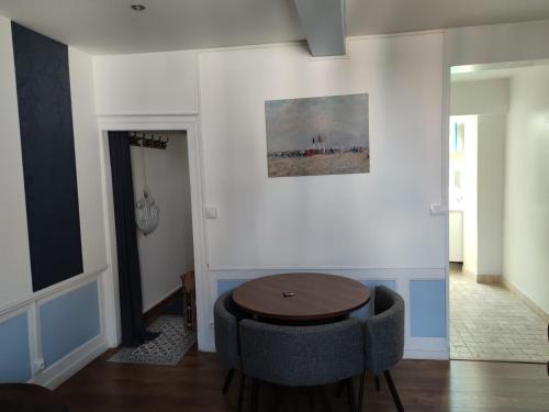 a living room with a table and a chair at Le Saint Léonard...Il est bleu in Honfleur