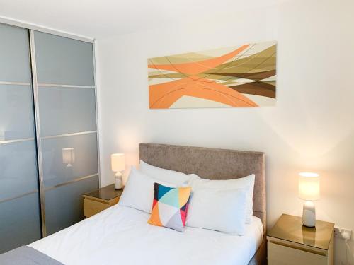 a bedroom with a bed and a painting on the wall at Cotels at The HUB Serviced Apartments, Superfast Broadband, Central Location, Free Parking in Milton Keynes