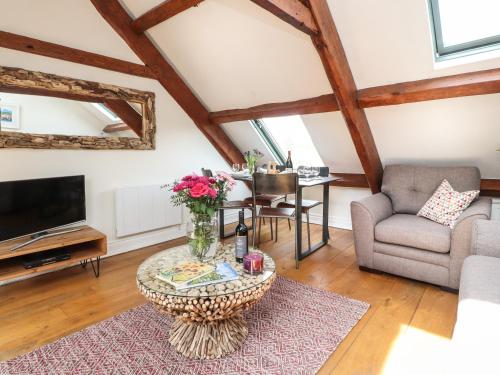 a living room with a table and a tv at 25 St Georges Quay in Lancaster