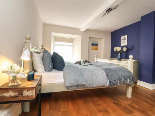 a bedroom with a bed with blue walls and a table at 25 St Georges Quay in Lancaster