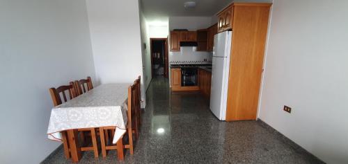 a kitchen with a table and a white refrigerator at LA MARINA III PRIMERO B in La Restinga