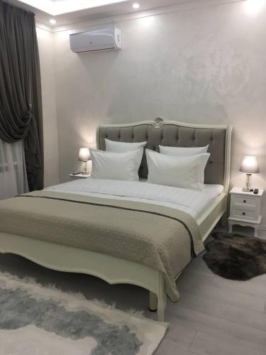 1 dormitorio con 1 cama grande con almohadas blancas en Sobor, en Vínnytsia