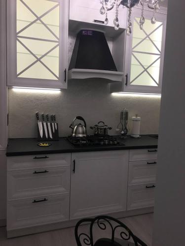 a kitchen with white cabinets and a stove at Sobor in Vinnytsya