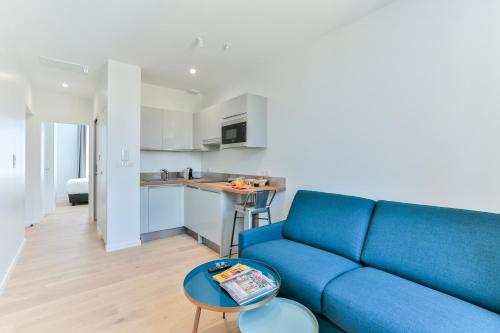 un salon avec un canapé bleu et une cuisine dans l'établissement VILLA14, à Dijon