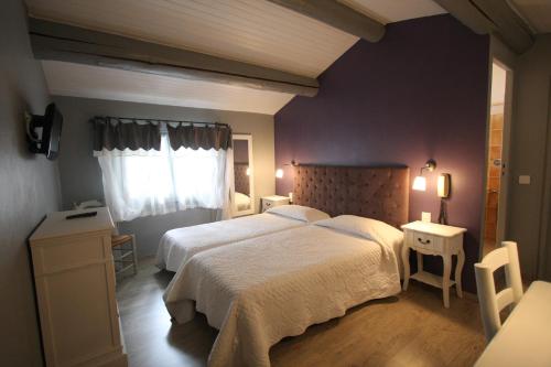 a bedroom with two beds and a window at Hotel Van Gogh in Saint-Rémy-de-Provence