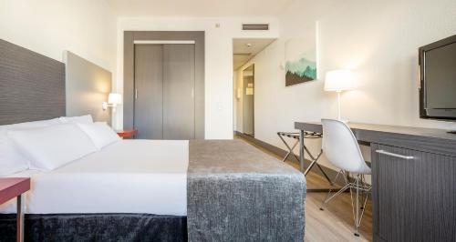 een hotelkamer met een bed en een flatscreen-tv bij Ilunion Romareda in Zaragoza