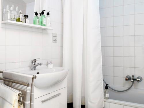 a white bathroom with a sink and a shower at Holiday home- Bungalow in Loosdrecht