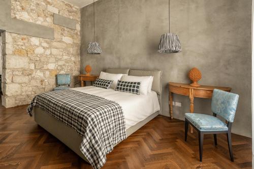 Schlafzimmer mit einem Bett, einem Tisch und Stühlen in der Unterkunft Suite San Tommaso - Ortigia Holidays in Syrakus
