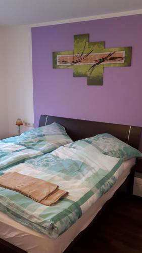 a bed in a bedroom with a painting on the wall at Traumreise mit Balkon zentral in Friedrichshafen