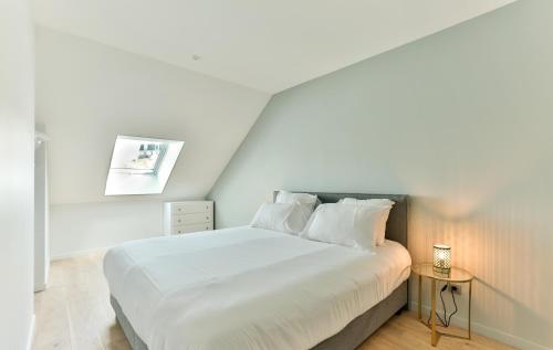 a bedroom with a large white bed and a table at VILLA14 in Dijon