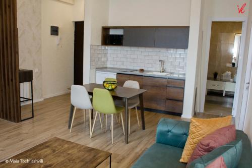 uma cozinha e sala de estar com mesa e cadeiras em Aura Sameba, Luxury Apartment em Tbilisi