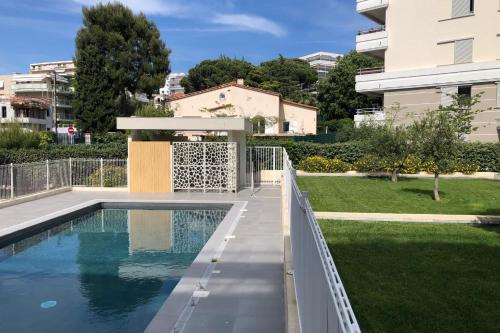 a swimming pool in a yard next to a building at Appartement Danaé Antibes in Antibes