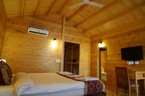 a bedroom with a bed in a wooden room at Golden Sands Resort, Morjim in Morjim