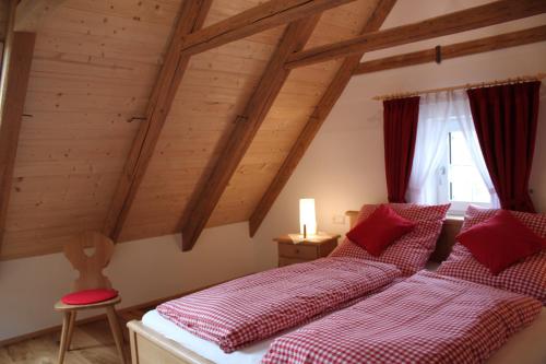 two beds in a room with wooden ceilings at Ferienwohnungen Zwergbachhof in Haunsheim
