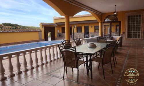 un patio con mesa y sillas junto a una piscina en Alojamiento Rural La Tiñosa, en Las Lagunillas