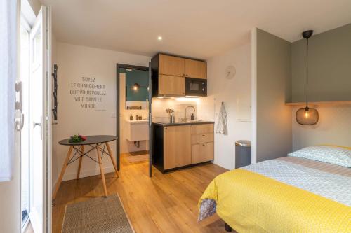 1 dormitorio pequeño con 1 cama y cocina en Maloca' Robretières, en La Roche-sur-Yon